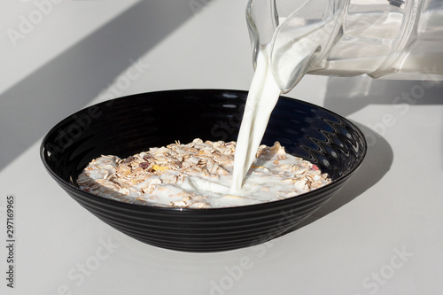Pouring milk in the dish with muesly