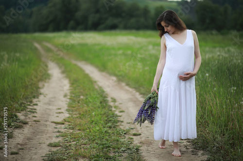 Pregnant woman in nature for a walk in the summer