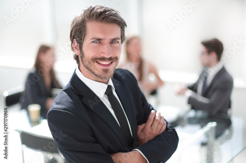 smiling young businessman standing in his office