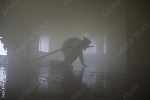 Firefighter crawls through smoke filled house photo