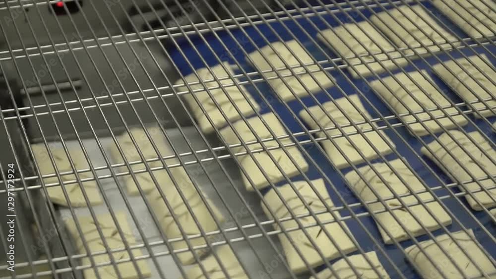 Production of puffs in a modern food factory. Buns move on the conveyor belt. Production of puffs in a modern food factory. Buns move on the conveyor belt.