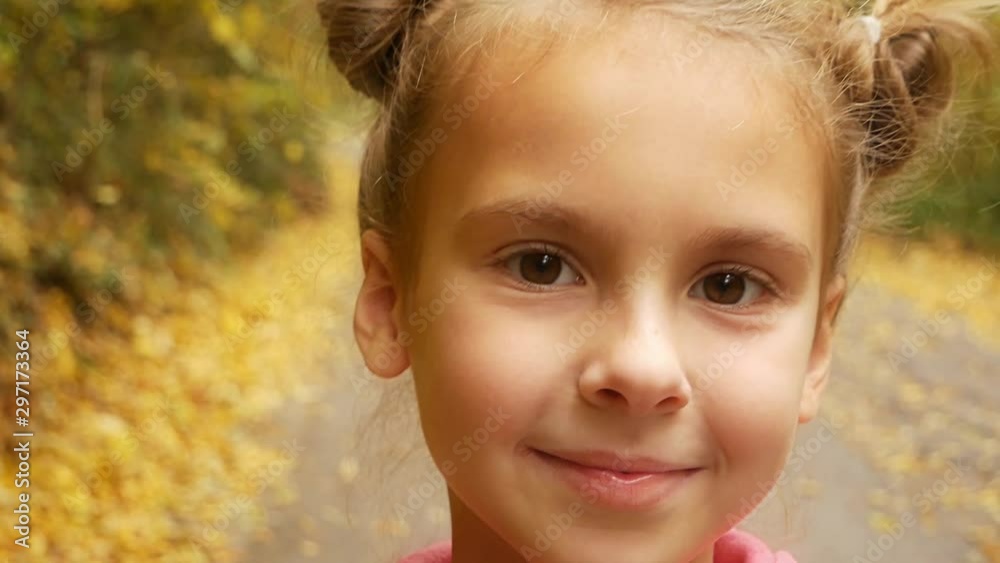 Cute girl looking into the camera and smiling. Autumn sunny day. Cute girl looking into the camera and smiling. Autumn sunny day.