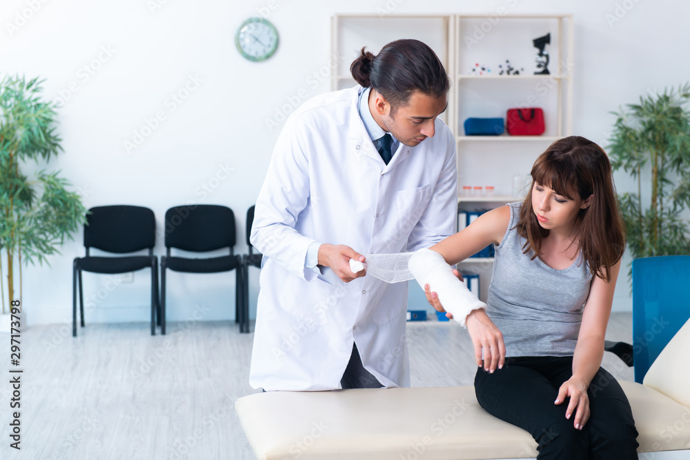 Young woman visiting male doctor traumatologist Young woman visiting male doctor traumatologist