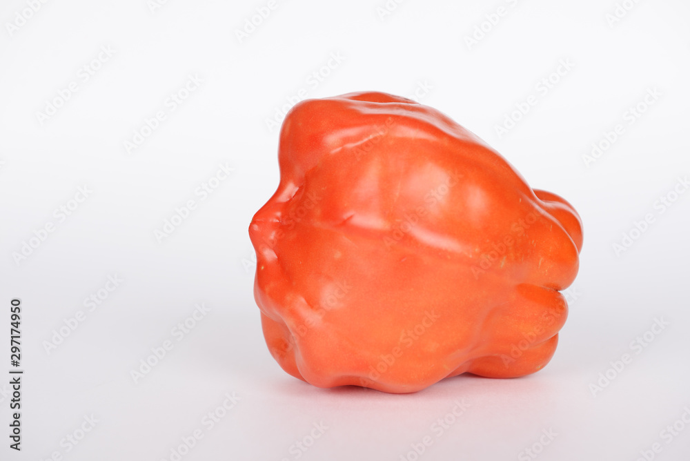 The tomato with shape of human face on white background The tomato with shape of human face on white background