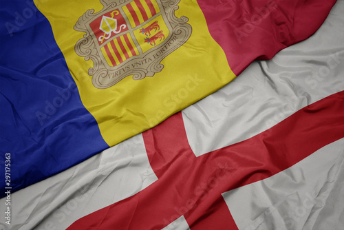 waving colorful flag of england and national flag of andorra.