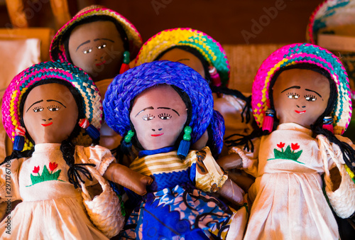 Row of rag dolls wearing traditional clothes and colorful straw hats, Madagascar