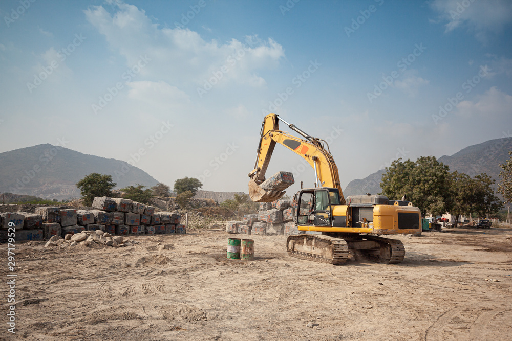 An Excavator moves a rough cut granite block into a stockyard in Ongole, India An Excavator moves a rough cut granite block into a stockyard in Ongole, India