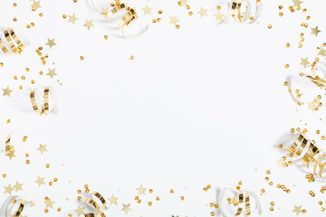 Christmas modern composition. Golden decorations, confetti, streamers, stars on white background. Christmas, New Year, winter concept. Flat lay, top view, copy space