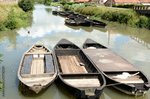 In the swamps, several barks named bacôve, trees ,water, houses, bridges. Summer, august in the Audomarois's swamps, St Omer in France. photo