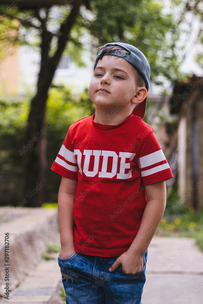 Portrait of a cute little boy in a cap and a red T-shirt. Cool kid Portrait of a cute little boy in a cap and a red T-shirt. Cool kid
