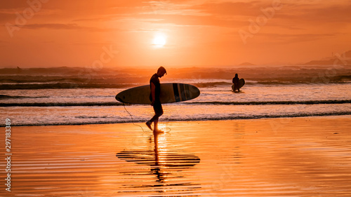 Tofino Vancouver Island, sunset at cox bay with surfers by the ocean during fall season Canada photo