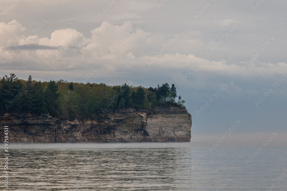 cliff over sea with trees and clouds
