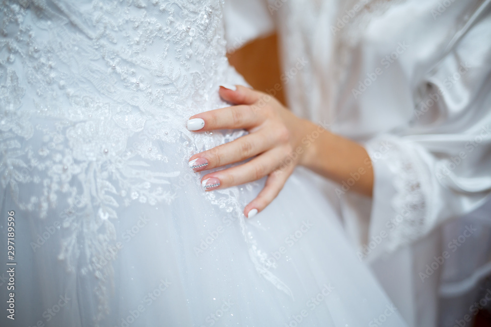 the bride holds in her hands a beautiful wedding dress the bride holds in her hands a beautiful wedding dress