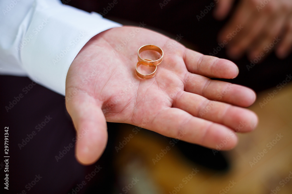 gold wedding rings in the hands of the newlyweds gold wedding rings in the hands of the newlyweds