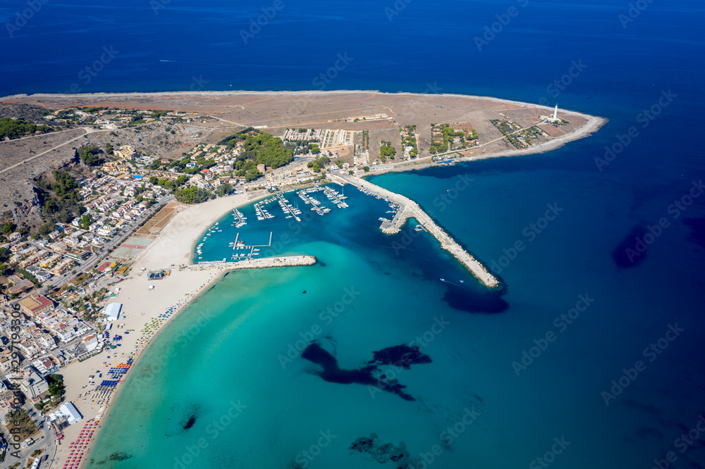Aerial view of San Vito Lo Capo,Sicily white sand beach. Sun loungers, umbrellas, city houses and the sea, view from a quadrocopter