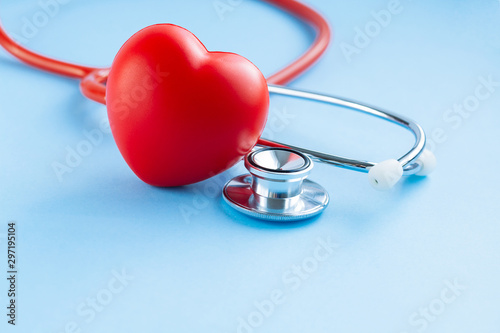 Stethoscope and red heart on blue background.