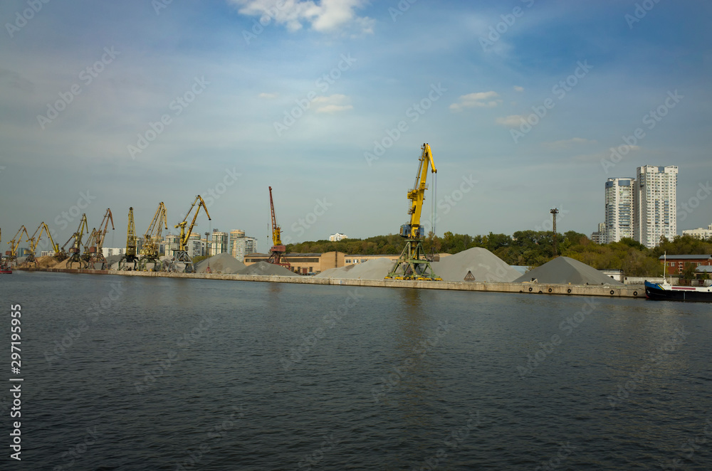 Moscow, Russia - September 8, 2018: Khimka River, Moscow Canal. Cargo terminal on the embankment, cranes, mountain crushed stone