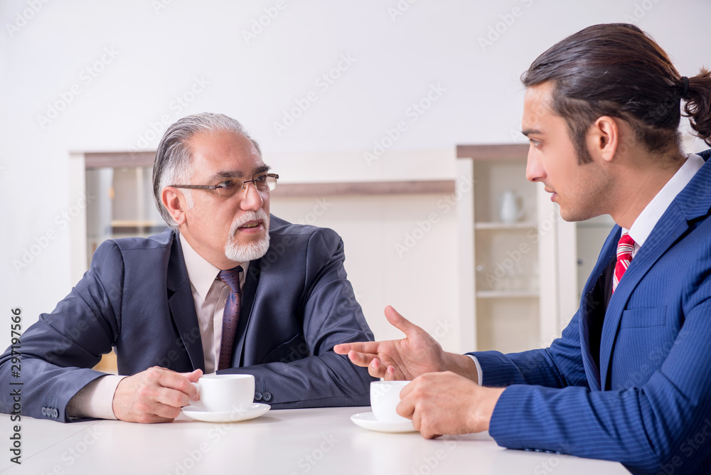 Two businessman discussing business in office Two businessman discussing business in office