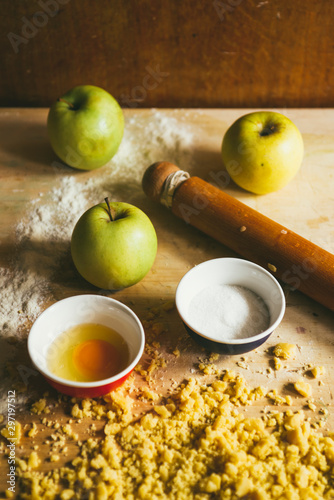Photography series how to make an apples crumble , from the ingredients to the finish cake, rustic environment, the ingredients and tools to prepare the crumble are collected on a table