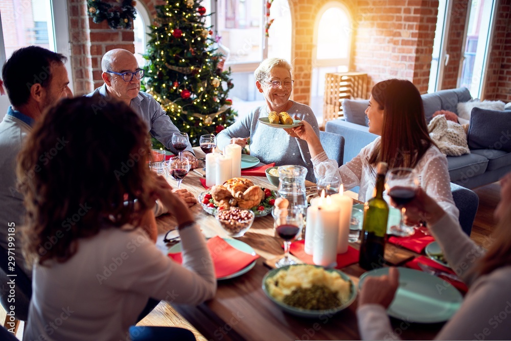 Family and friends dining at home celebrating christmas eve with traditional food and decoration, celebration of festive winter time