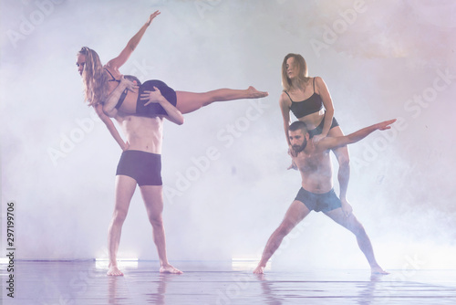 Fototapeta Naklejka Na Ścianę i Meble -  Young modern dancers dancing in the studio. Sport, dancing and urban culture concept. Group of young dancers performing on the stage. Effective performance. beautiful dance. full of energe dancers.