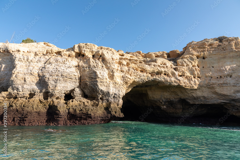 Beautiful landscape of Algarve, Portugal coast with sandstone cliffs, beach and ocean under cloudless blue sky