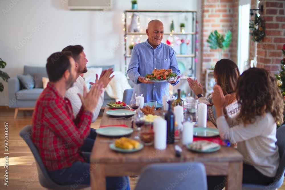 Beautiful family smiling happy and confident. Showing roasted turkey and applauding celebrating Christmas at home Beautiful family smiling happy and confident. Showing roasted turkey and applauding celebrating Christmas at home