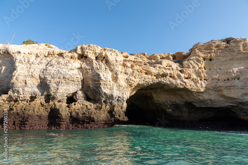 Beautiful landscape of Algarve  Portugal coast with sandstone cliffs  beach and ocean under cloudless blue sky