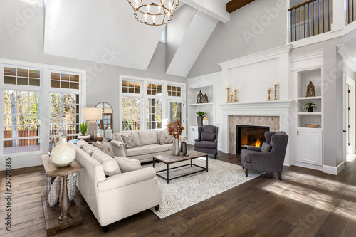 Beautiful living room in new traditional style luxury home. Features vaulted ceilings, fireplace with roaring fire, and elegant furnishings. photo