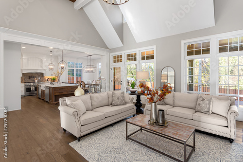 Living room and kitchen in new traditional style uxury home. Features vaulted ceilings and open conept floor plan. Includes dining room. photo