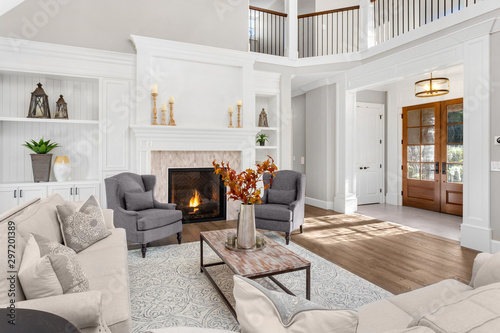 Beautiful living room in new traditional style luxury home. Features vaulted ceilings, fireplace with roaring fire, and elegant furnishings.