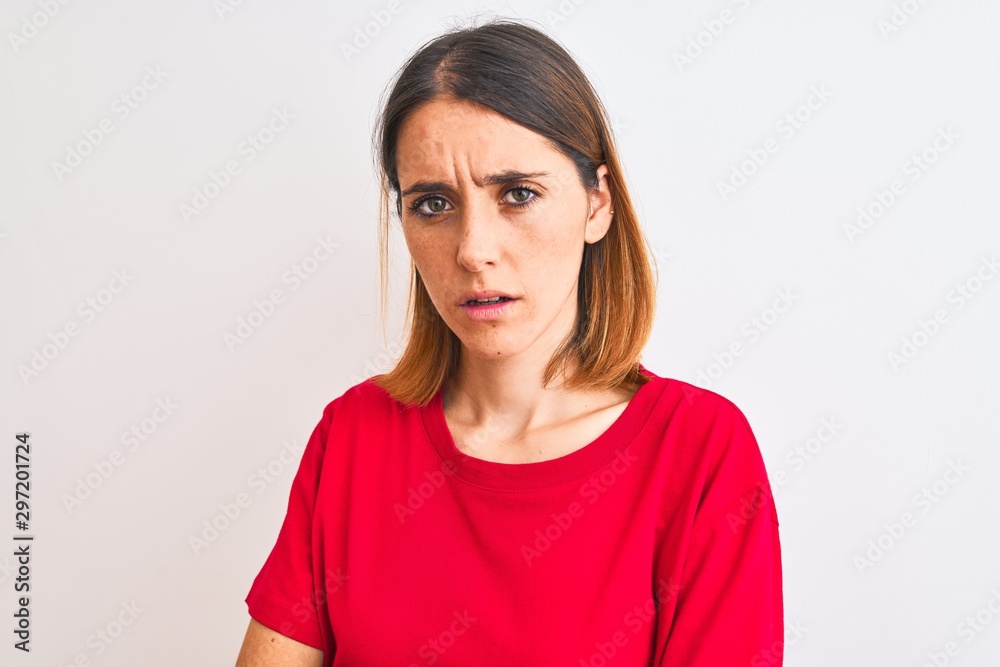 Beautiful redhead woman wearing casual red t-shirt over isolated background skeptic and nervous, disapproving expression on face with crossed arms. Negative person. Beautiful redhead woman wearing casual red t-shirt over isolated background skeptic and nervous, disapproving expression on face with crossed arms. Negative person.