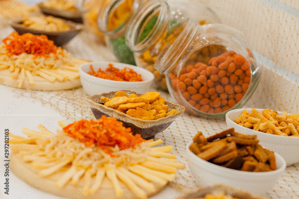 A lots of salty snacks on a table, many cheese and crackers on the table with snacks