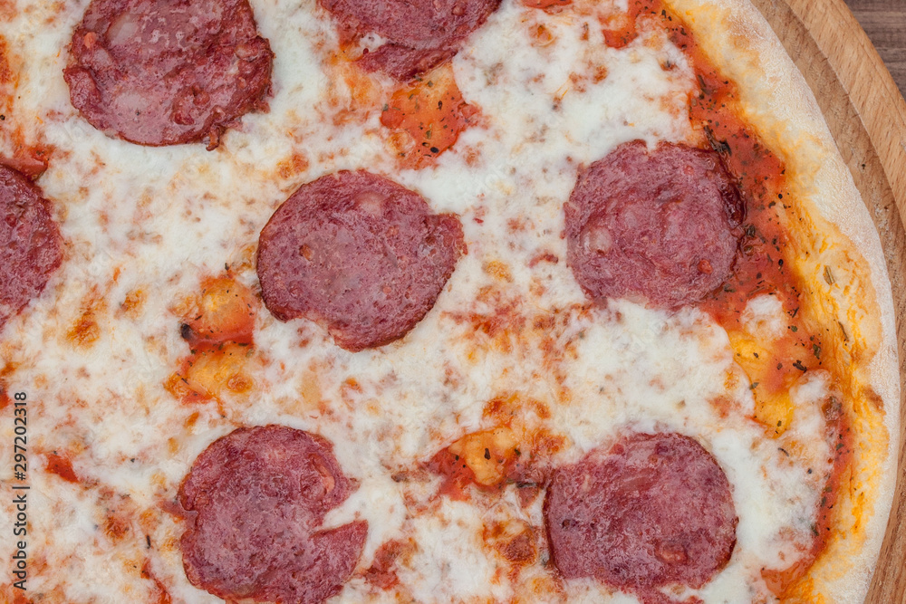 Italian Pepperoni pizza with salami on dark wooden background top view. Italian traditional food. Popular street food