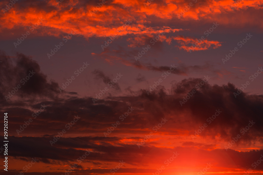 Fiery orange sunset  colorful and speckled  clouds.