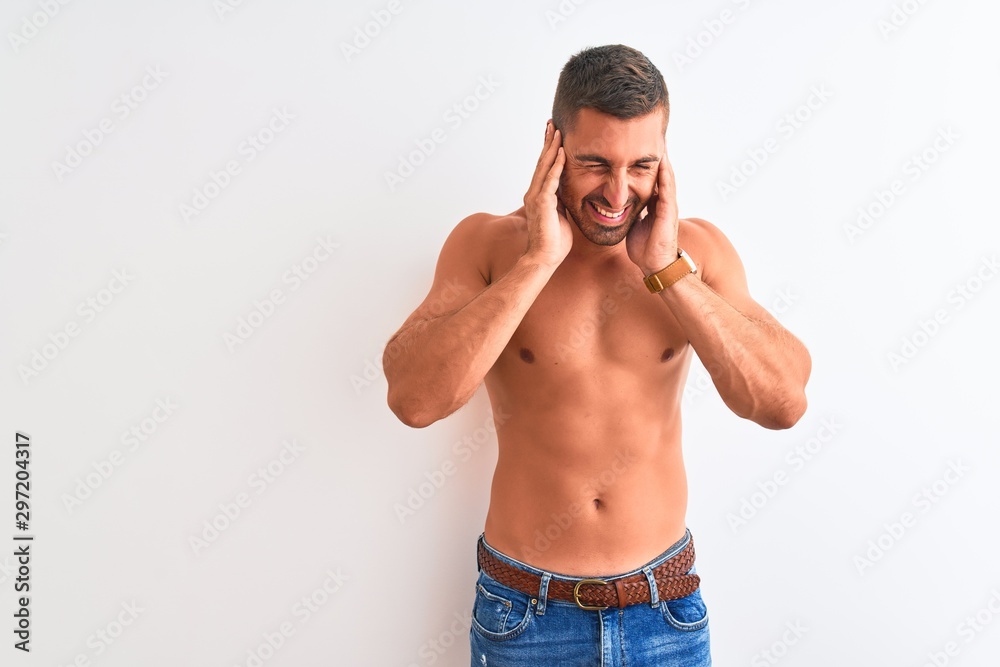 Fototapeta premium Young handsome shirtless man showing muscular body over isolated background covering ears with fingers with annoyed expression for the noise of loud music. Deaf concept.