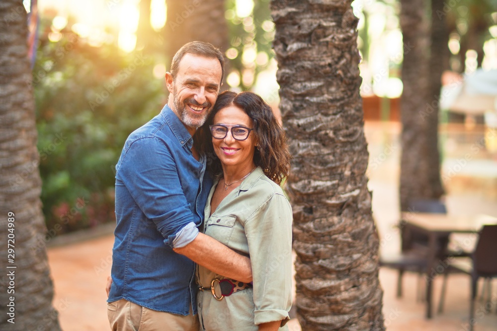 Middle age beautiful couple smiling happy and confident at town park. Standing with smile on face and hugging Middle age beautiful couple smiling happy and confident at town park. Standing with smile on face and hugging