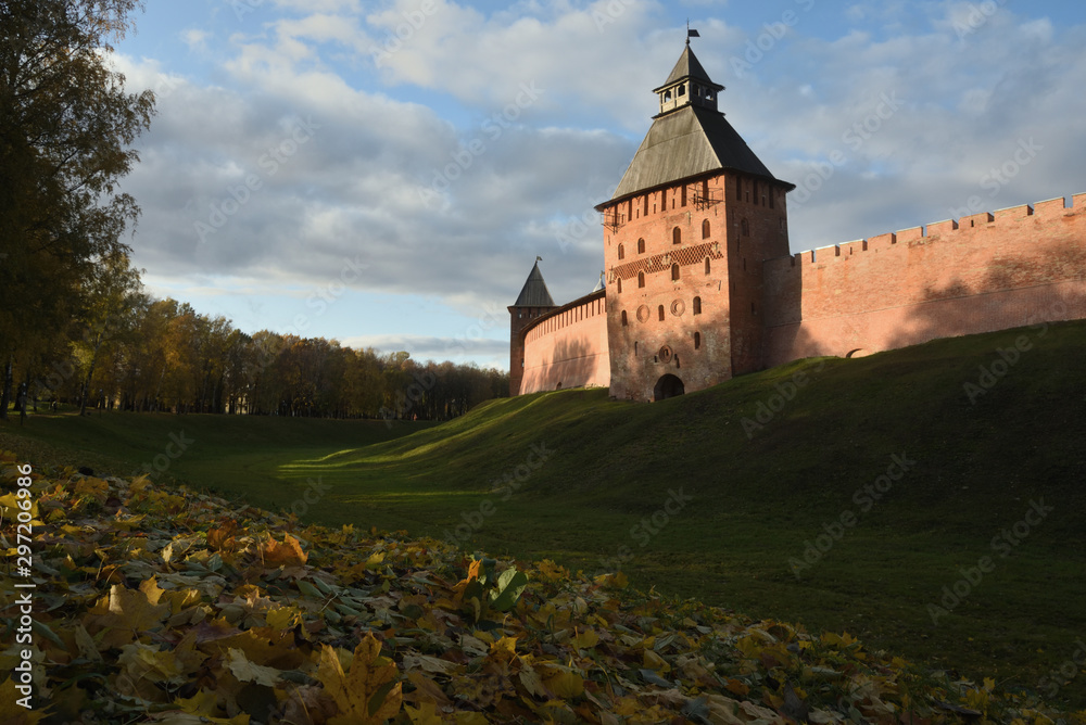 Autumn park with fallen leaves in the foreground and ancient towers. Veliky Novgorod. Novgorod Kremlin