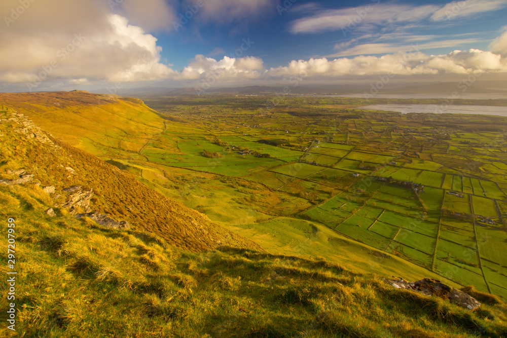 Beautifull weather in Irish mountains and green grass. View from top of the Ben Bulben moutain in Sligo, Ireland. Dramatic sky during summer sunset.