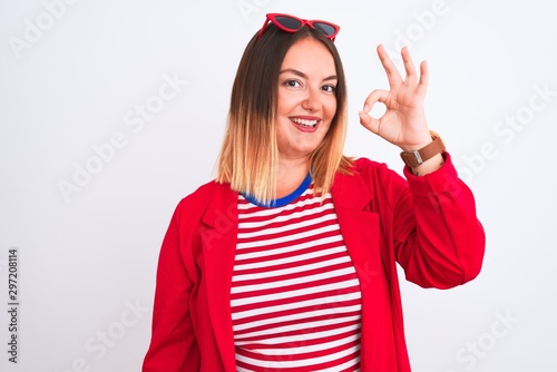 Young beautiful woman wearing striped t-shirt and jacket over isolated white background smiling positive doing ok sign with hand and fingers. Successful expression.
