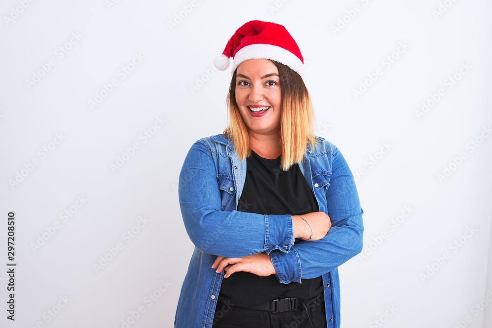 Young beautiful woman wearing Christmas Santa hat standing over isolated white background happy face smiling with crossed arms looking at the camera. Positive person.