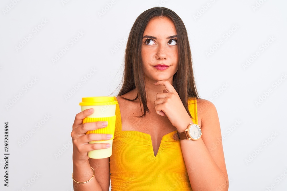 Young beautiful girl drinking paper glass of take away coffee over isolated white background serious face thinking about question, very confused idea Young beautiful girl drinking paper glass of take away coffee over isolated white background serious face thinking about question, very confused idea