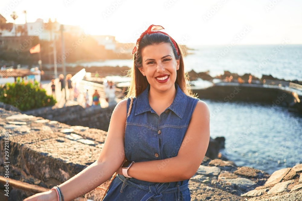 Beautiful young woman walking on beach promenade enjoying ocean view smiling happy on summer vacation