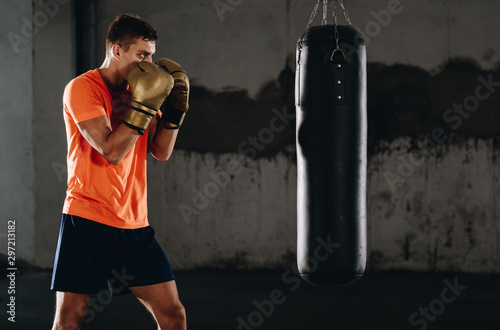 Horizontal view of handsome sporty man training boxing