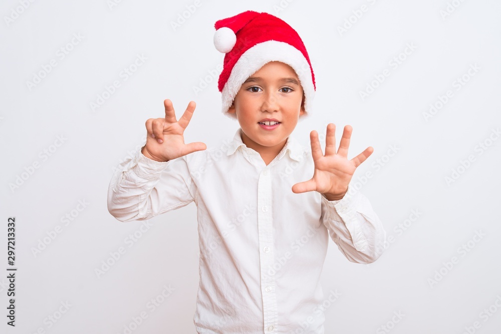 Beautiful kid boy wearing Christmas Santa hat standing over isolated white background showing and pointing up with fingers number eight while smiling confident and happy. Beautiful kid boy wearing Christmas Santa hat standing over isolated white background showing and pointing up with fingers number eight while smiling confident and happy.