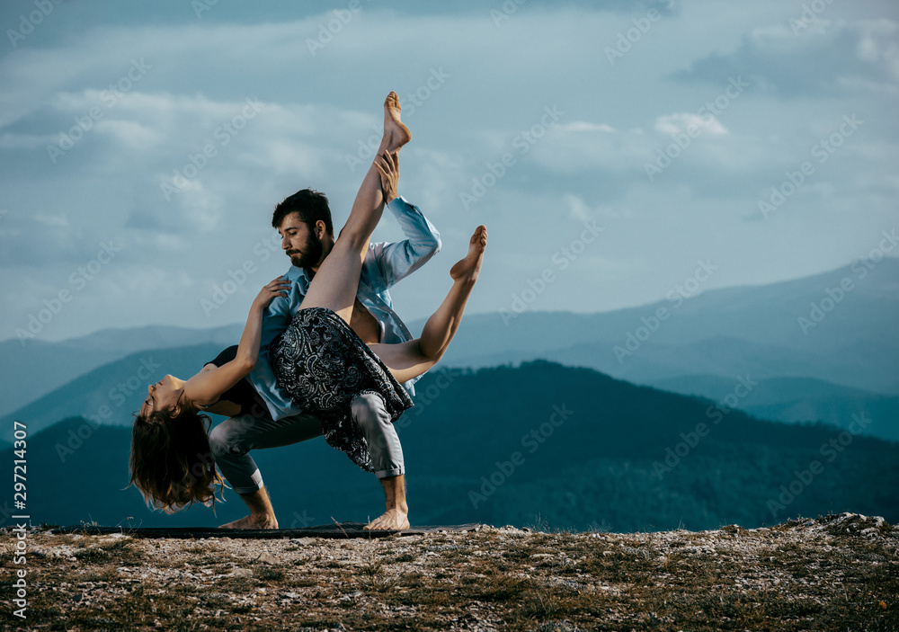 Two modern dancers practicing dancing on the mountain cliff - obrazy, fototapety, plakaty 