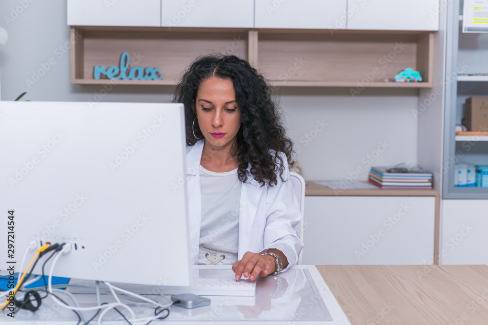 Portrait of a nurse ( female physician ) typing a medical report on her computer in the lobby. Portrait of a nurse ( female physician ) typing a medical report on her computer in the lobby.