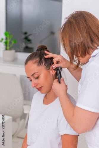Female doctor performing an otolaryngological exam on a cute teen girl..