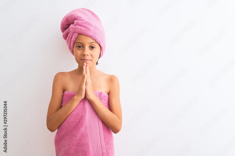 Beautiful child girl wearing shower towel after bath standing over isolated white background praying with hands together asking for forgiveness smiling confident. Beautiful child girl wearing shower towel after bath standing over isolated white background praying with hands together asking for forgiveness smiling confident.