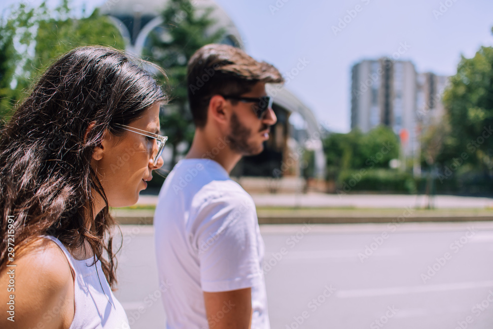Side view of walking caucasian couple in urban area Side view of walking caucasian couple in urban area